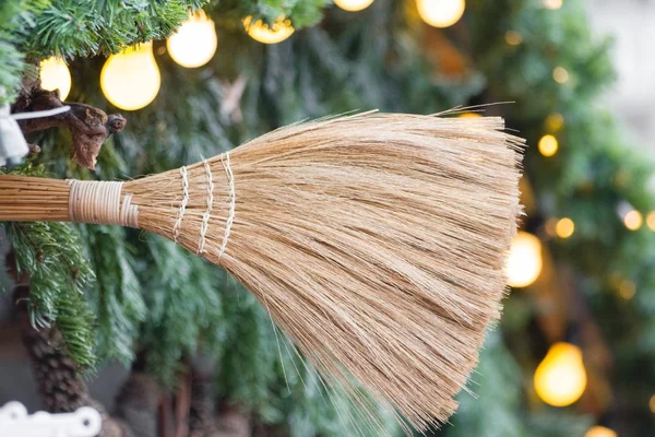 Broom close-up with pine branches and light bulbs — Stock Photo, Image
