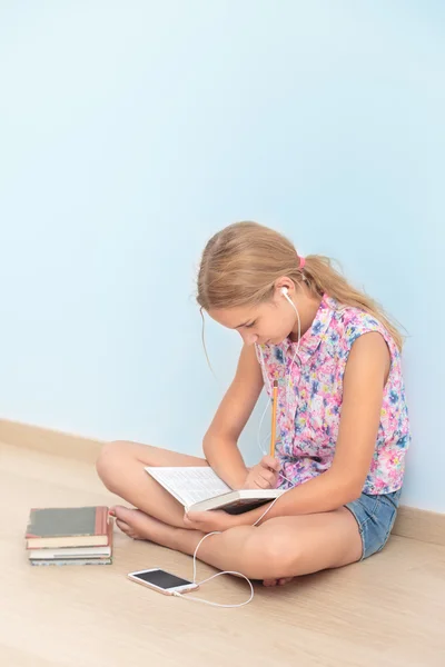 Colegiala leyendo un libro en el aula — Foto de Stock