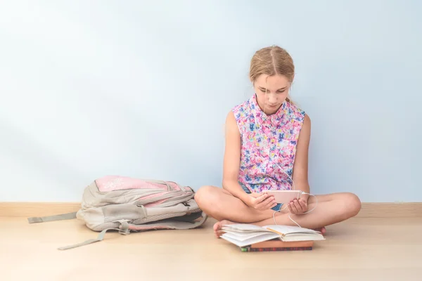 Schoolgirl reading a book in classroom — Stock Photo, Image