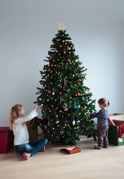 Fiatal lány és az ő kis húga, karácsonyfa díszítés — Stock Fotó