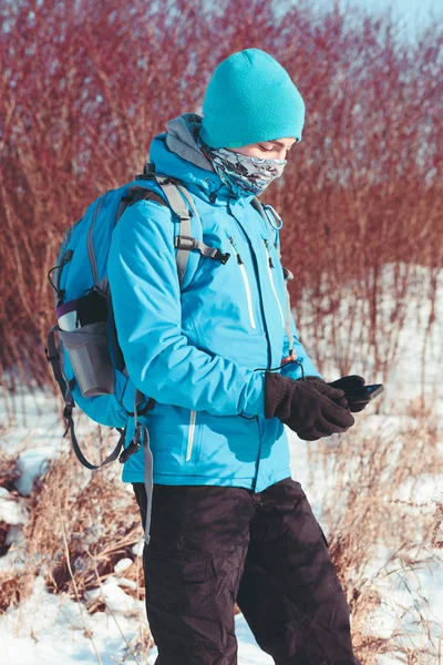 Хлопчик використовує мобільний телефон під час зимової подорожі — стокове фото