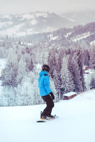 Junge reitet mit Snowboard den Hang hinunter — Stockfoto