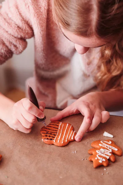 Tjej dekorera bakade Pepparkakor jul med frostin — Stockfoto