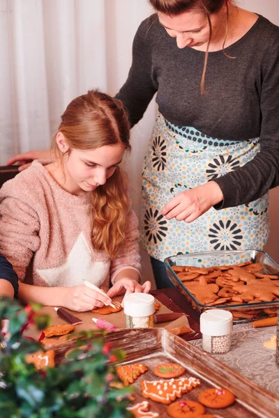 Menina decorando biscoitos de gengibre de Natal com cobertura — Fotografia de Stock