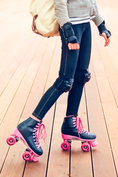 木製のステージ上に立っている若いローラー スケートの足 — ストック写真