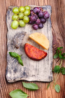 Peynir ve el yapımı seramik plaka üzerinde üzüm