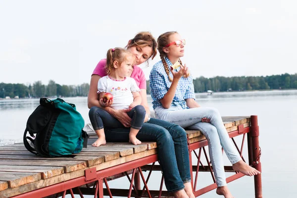Familjen tillbringar tid tillsammans sitter på brygga över sjön i — Stockfoto