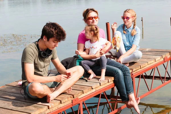 Familjen tillbringar tid tillsammans sitter på brygga över sjön i — Stockfoto