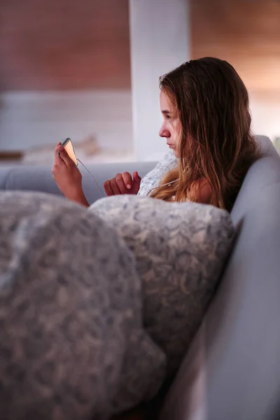 Chica viendo vídeo en línea en el teléfono inteligente en casa — Foto de Stock