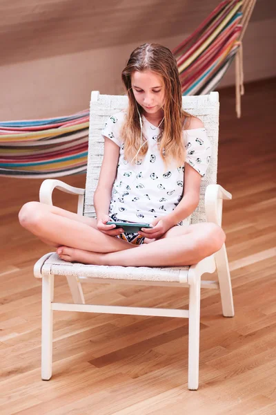 Dívka, poslech hudby na smartphone doma — Stock fotografie