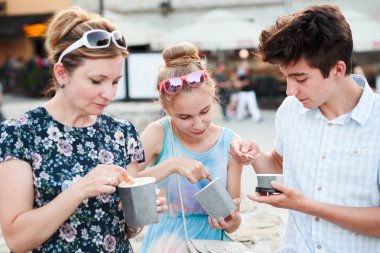 Aile vakit şehir merkezinde birlikte zevk bir yaz gününde dondurma yemek. Anne, genç kız ve kaliteli zaman geçirmek güneşli öğleden sonra yemek tatlı tatlı çocuk. Kent merkezinde, eski şehir içinde belgili tanımlık geçmiş