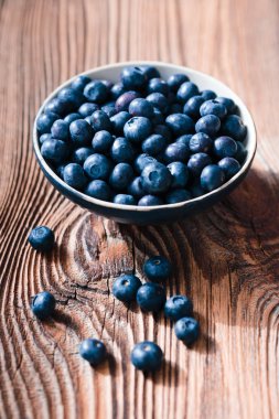 Taze toplanmış yabanmersini seramik kasenin içine koymak. Bazı meyve 