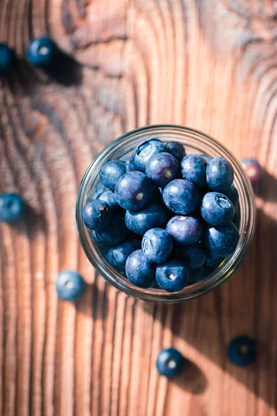 Arándanos recién recogidos puestos en frasco. Algunas frutas dispersas — Foto de Stock