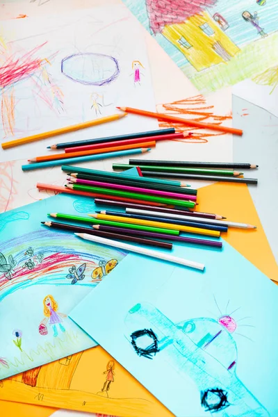 Pastelli a matita sparsi sul desktop pieni di disegni colorati — Foto Stock