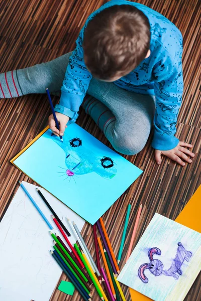 Kleine jongen een kleurrijke foto van een auto met behulp van potlood cray tekening — Stockfoto