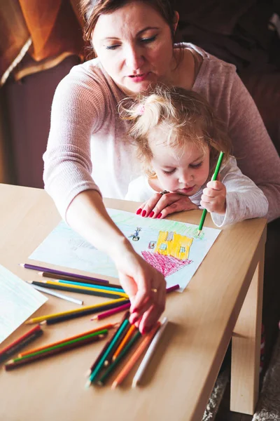 Mamá con hija pequeña dibujando cuadros coloridos usando penci — Foto de Stock