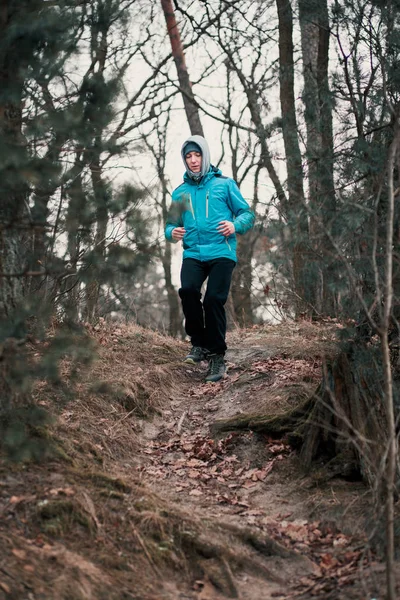 Νεαρός άνδρας τρέξιμο σε εξωτερικούς χώρους κατά τη διάρκεια της προπόνηση σε ένα δάσος μεταξύ φύλλων — Φωτογραφία Αρχείου