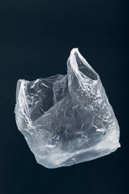 Siyah arkaplanda yüzen beyaz boş plastik torba