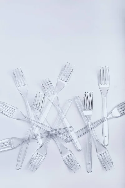 Plastic forks scattered over white background