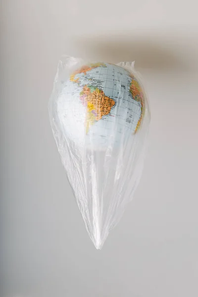 Globus in einer Plastiktüte. Erde durch Plastikmüll kontaminiert — Stockfoto