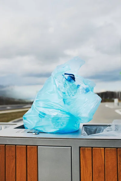 Plastic bag full of plastic waste put on outdoor trash. Plastic waste to recycling. Concept of plastic pollution and recycling plastic waste. Environmental issue. Environmental damage. Real people, authentic situations