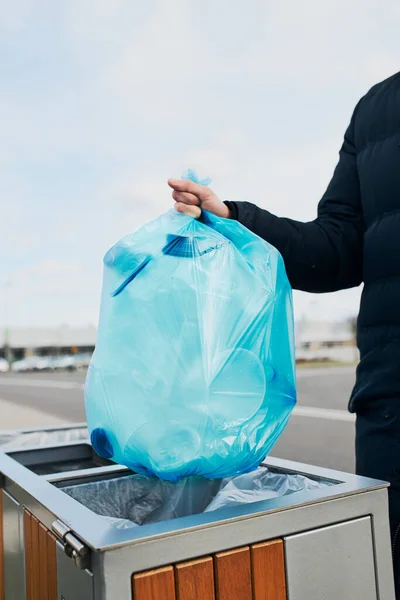 Man throwing a bag full of plastic waste to trash. Plastic waste to recycling. Concept of plastic pollution and recycling plastic waste. Environmental issue. Environmental damage. Real people, authentic situations