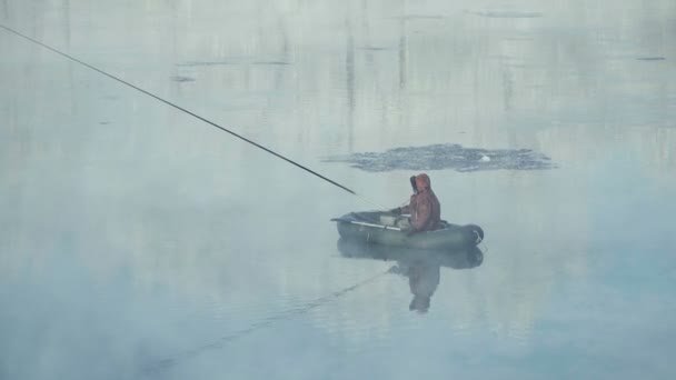 The fisherman is fishing on a boat. Winter fishing. An ice floe passes by. — Stock Footage Fisherman Fishing Boat Winter Fishing Ice Floe Passes Stock Footage