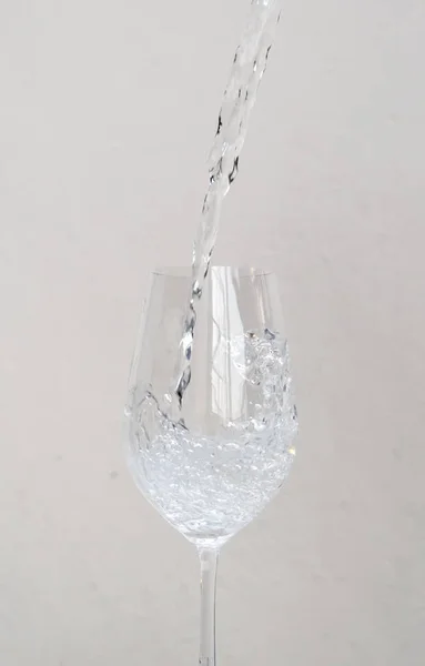 Pour water into a glass of wine