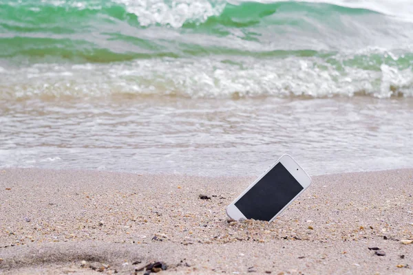 Потерянный смартфон исчез на пляже — стоковое фото