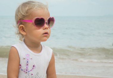 Denizin zemin karşı sahilde güneş gözlüklü çocuk.