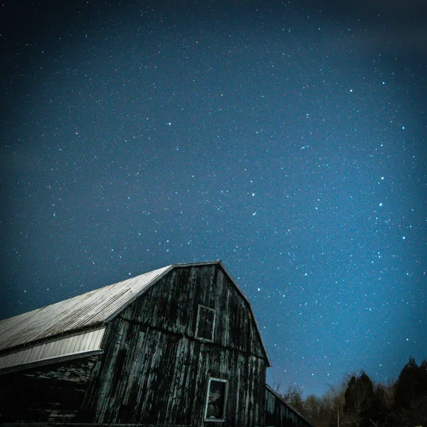 Old rustic barn with Big Dipper and Pole star in winter