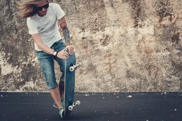 Молодой человек делает трюк со скейтбордом — стоковое фото