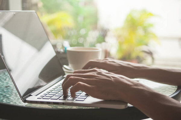 Close-up of male hands using laptop