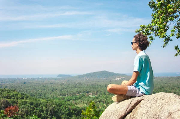 Homem no topo da montanha sentado na rocha assistindo vista pitoresca — Fotografia de Stock