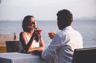 Romantik Çift sunset Restaurant sahilde kokteyl içme keyfini çıkarın