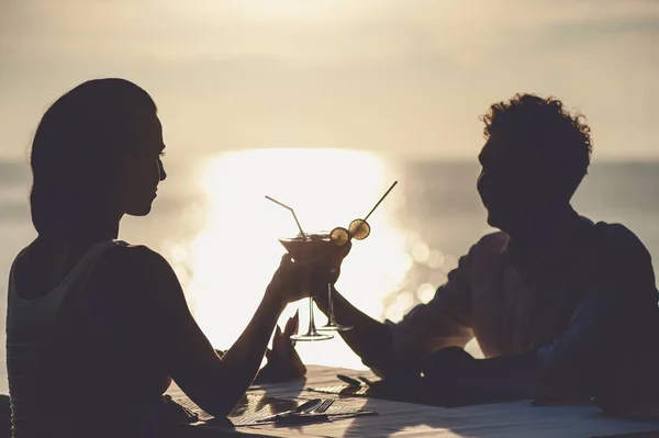 Casal romântico desfrutar do pôr do sol no restaurante na praia beber coquetéis — Fotografia de Stock