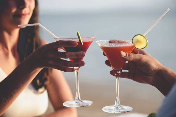 Casal romântico desfrutar do pôr do sol no restaurante na praia beber coquetéis — Fotografia de Stock