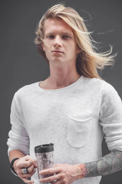 Genç adam sarışın gri duvar dövme ile portresi