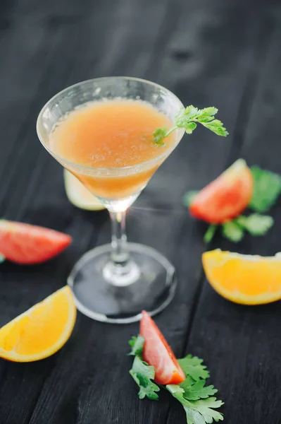 Coctail with orange and tomato on black wooden table at blurred background — Stock Photo, Image