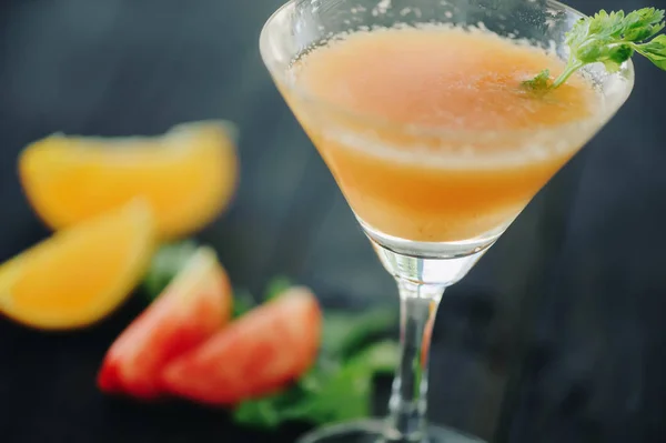 Coctail with orange and tomato on black wooden table at blurred background — Stock Photo, Image