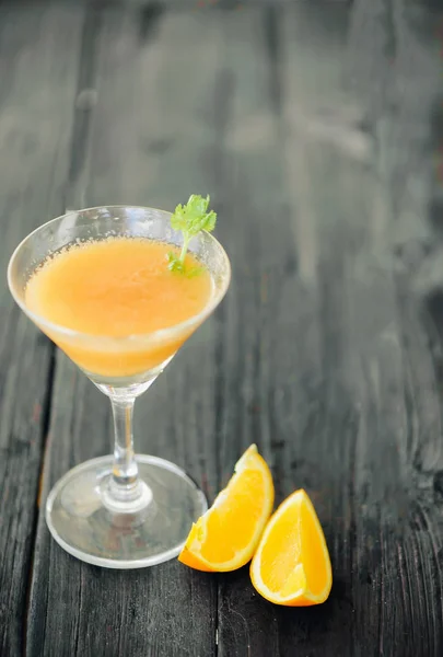 Orange coctail on black wooden table at blurred background — Stock Photo, Image
