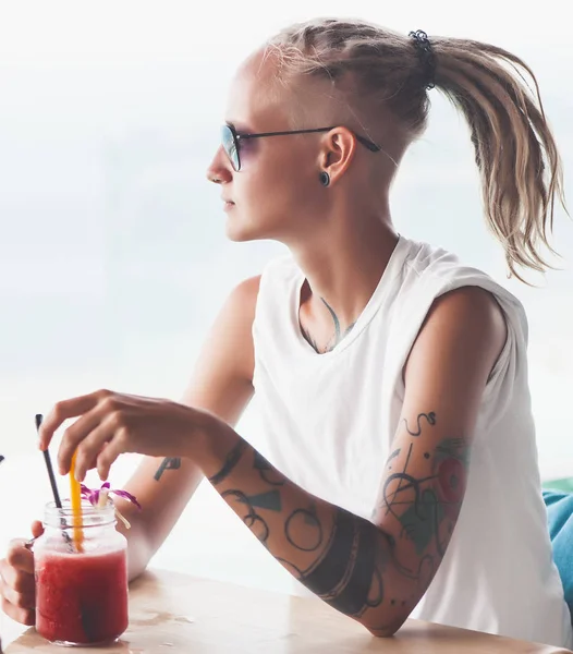 Νεαρή γυναίκα με dreadlocks κάθεται σε πόσιμο smoothie καφέ — Φωτογραφία Αρχείου