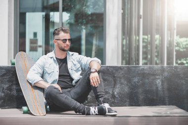 Adam oturup kaykay ile.