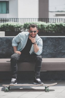 Adam oturup kaykay ile.