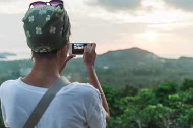 Genç kadın günbatımı manzara fotoğrafını ayakta