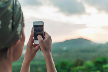 Genç kadın günbatımı manzara fotoğrafını ayakta