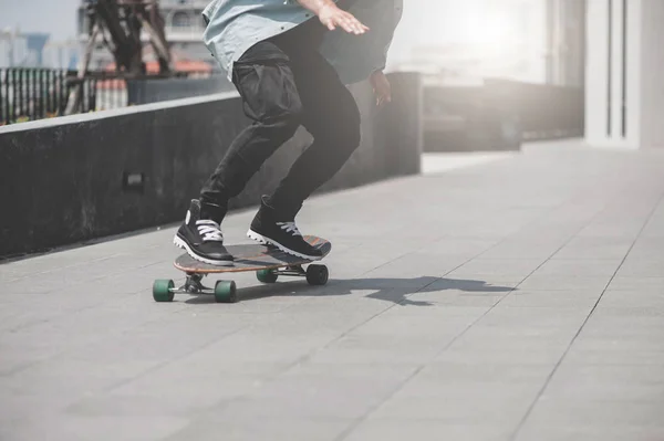 Close up of skater\'s legs on the longboard riding at the street in outdoors