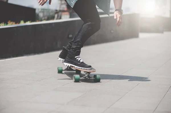 Close up of skater\'s legs on the longboard riding at the street in outdoors