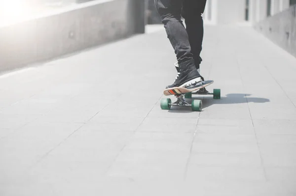 Close up de pernas de patinador no longboard equitação na rua ao ar livre — Fotografia de Stock