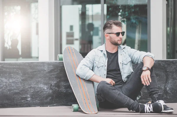 Man zitten met skateboard. — Stockfoto